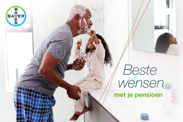 A man with shaving cream on his face and a child playfully pointing at him in a bathroom. Text reads, "Beste wensen met je pensioen" and displays the Bayer logo.