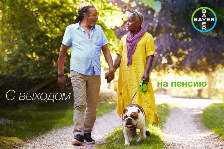 A couple walks hand-in-hand with a bulldog on a sunny path. Russian text reads "With retirement" near a Bayer logo.