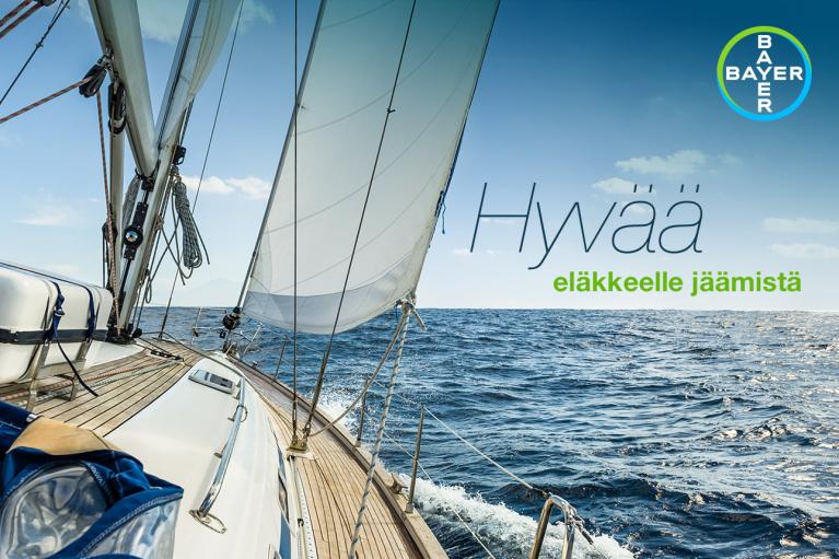 View from the deck of a sailing boat on the ocean with a Bayer logo and Finnish text saying "Hyvää eläkkeelle jäämistä" meaning "Happy retirement.
