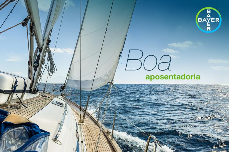 Sailing boat on the ocean with "Boa aposentadoria" text and Bayer logo on a clear day.