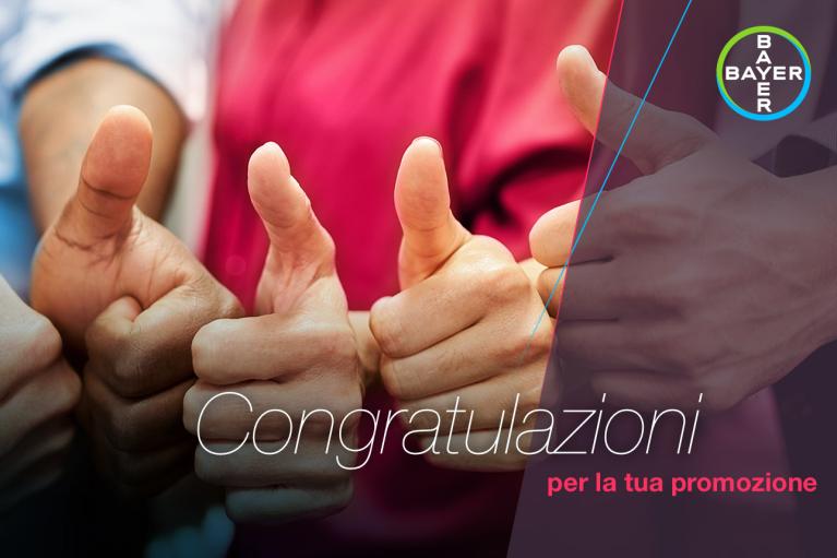 Four people giving thumbs up. Text reads "Congratulazioni per la tua promozione" with a Bayer logo in the corner.