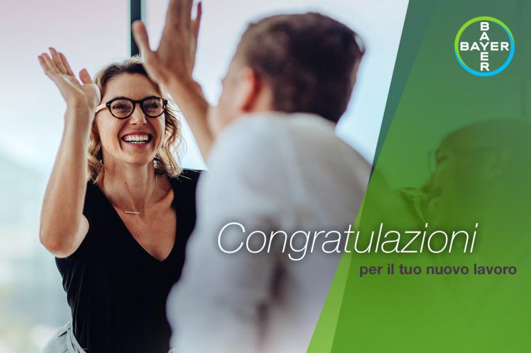 Two people high-fiving with smiles. The words "Congratulazioni per il tuo nuovo lavoro" and a Bayer logo are visible.