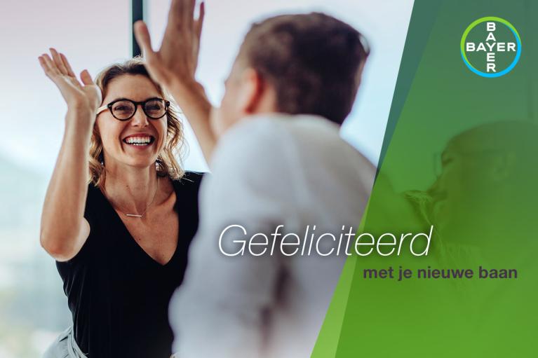 A woman and a man celebrate with a high five. Text reads, "Gefeliciteerd met je nieuwe baan" with a Bayer logo.