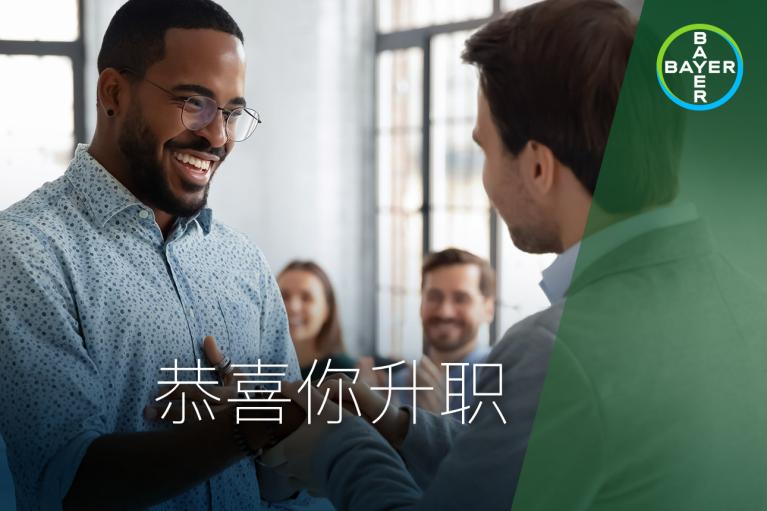Two men shake hands in an office setting, with two people smiling in the background. The Bayer logo is in the top corner, and Chinese text is overlaid on the image.