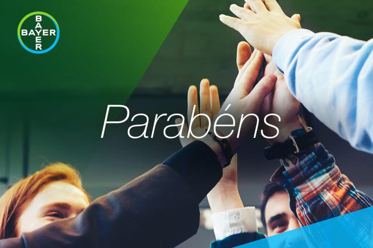 Group with raised hands touching and the word "Parabéns"