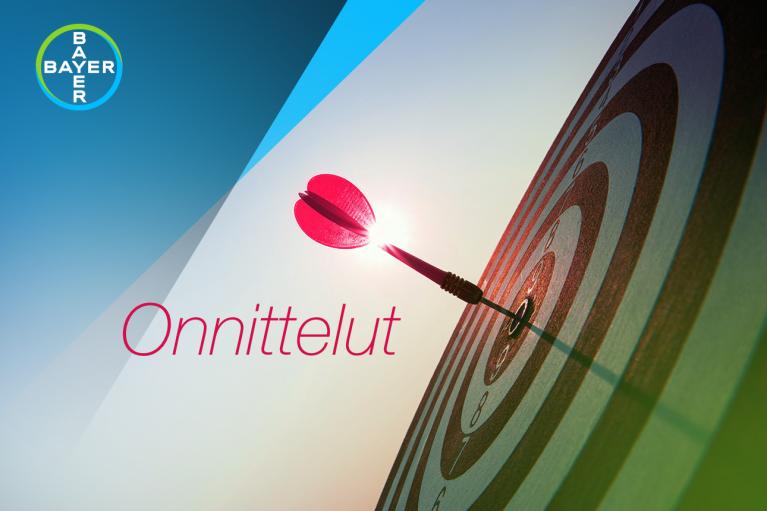 Target with a dart in the center and the word "Onnittelut"