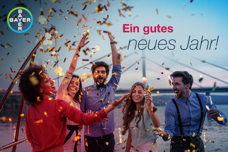 Ein gutes neues Jahr! Group of people throwing confetti in front of bridge