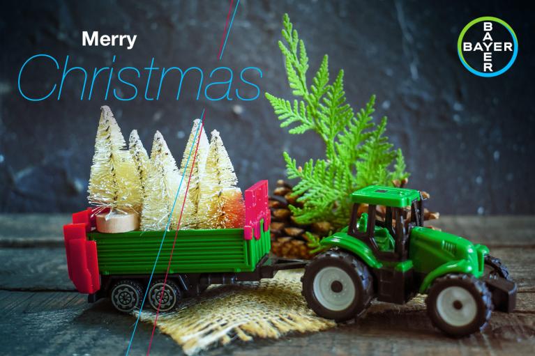 Toy tractor with trailer and fir trees