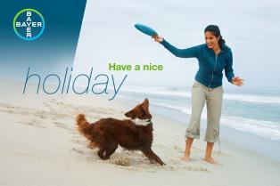 Woman playing fetch with a dog on a beach. Text reads "Have a nice holiday" next to the Bayer logo.