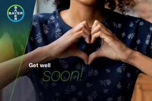 Person making a heart shape with hands near their chest, next to the text "Get well soon!" and a Bayer logo.