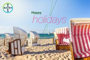 A beach scene with striped beach chairs and a calm sea. Text reads "Happy Holidays" alongside the Bayer logo.