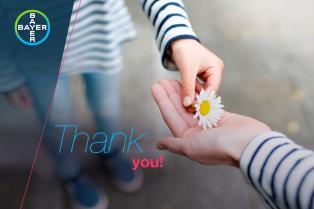 Two hands exchange a daisy flower. The words "Thank you!" are overlaid. A Bayer logo is in the top left corner.