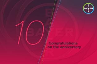 Red anniversary card with the number "10" and the message "Congratulations on the anniversary" alongside the Bayer logo.
