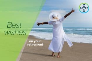 Person in white dress and hat joyfully stretches arms on a beach. Overlaid text reads "Best wishes on your retirement" next to Bayer logo.