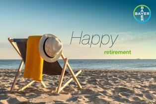 A deck chair with a hat and towel sits on a sandy beach facing the sea. Text reads "Happy retirement." The Bayer logo is in the top right corner.