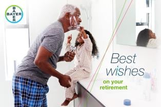 Older man shaving while a young girl touches his face. Text reads, "Best wishes on your retirement." Bayer logo in the top left corner.