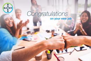 Two people fist-bumping in an office setting with colleagues clapping in the background. Text reads, "Congratulations on your new job.